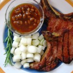 The finished meal: Rosemary and Orange Brined Pork Chops, Ensalda Blanca, plated with baked beans.