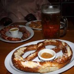 A feast of Oktoberfest goodies: pretzel, sausages, and of course - beer.