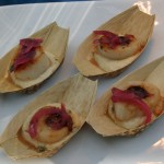 Scallop on a bed of polenta topped with marinated red onion