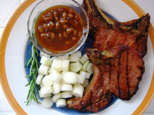 <p>The finished meal: Rosemary and Orange Brined Pork Chops, Ensalda Blanca, plated with baked beans.</p>