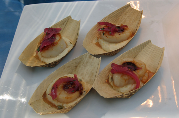 Scallop on a bed of polenta topped with marinated red onion