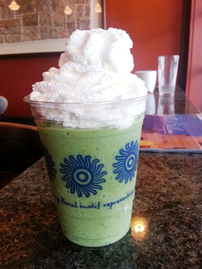 Trying a Matcha Green Tea Latte, blended with ice and topped with whipped cream.