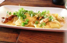 Crab ravioli with fresh crab, English peas and melted tomatoes