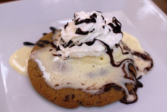 Freshly baked chocolate chip cookie with ice cream.