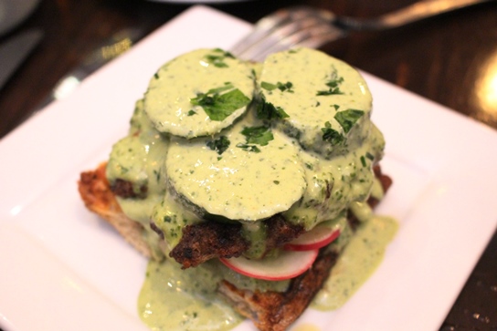 The open faced lamb burger smothered kale tahini sauce.