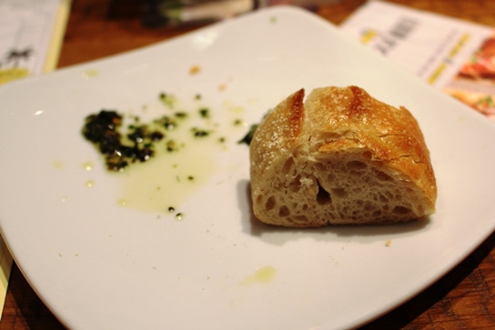 Freshly baked bread and the remains of herbed olive oil used for dipping.