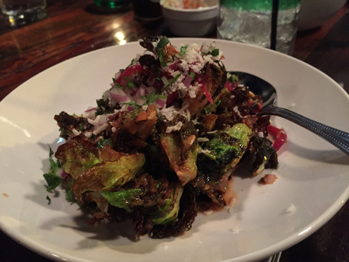 Brussel sprouts blistered and seared in chipotle aioli, pickled onion and herbs