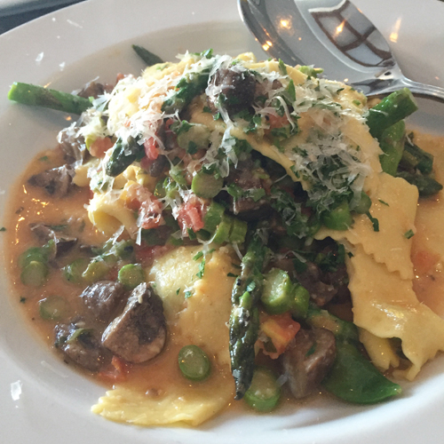 Hand cut pasta squares with fresh tomatoes, asparagus and mushrooms in a white wine sauce