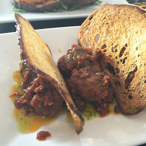 Hand rolled meatballs served with a spicy red sauce.