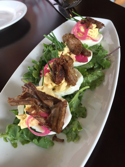 Deviled eggs topped with smoked pork