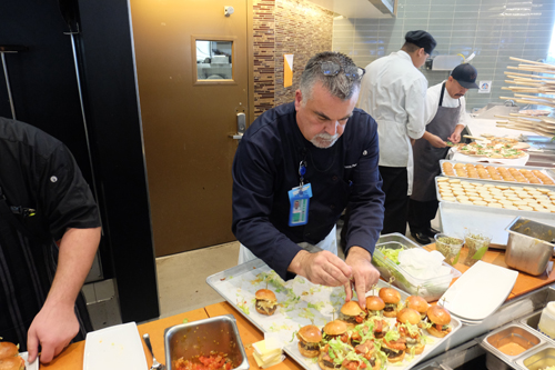 WPizza chef placing the finishing touches on the sliders