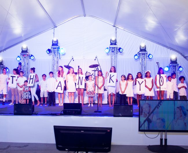 Kids spell out thank you on stage. Photo courtesy of Walk With Sally.